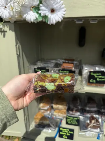 A person is holding a piece of cake in a plastic bag.