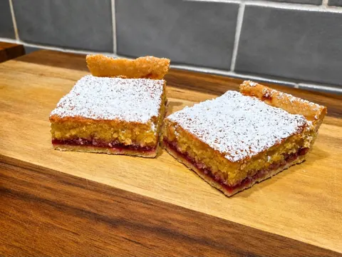 Two pieces of cake on a wooden table.