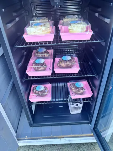 A refrigerator with a pink interior and a white tray inside.