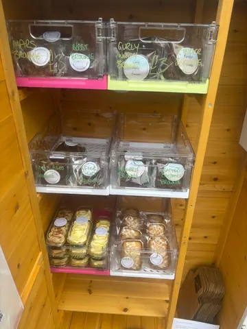A wooden shelf with a variety of food items on it.