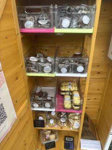 A wooden shelf with a variety of cakes and pastries.