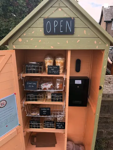 A small wooden building with a sign that says open.