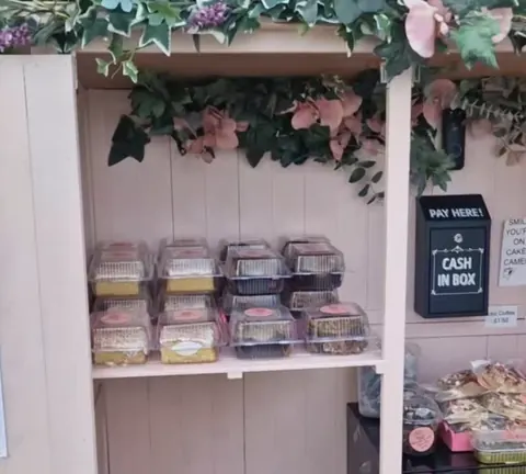 A wooden shelf with a sign that says "Pay Here".