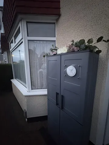 A gray trash can with a white circle on it.