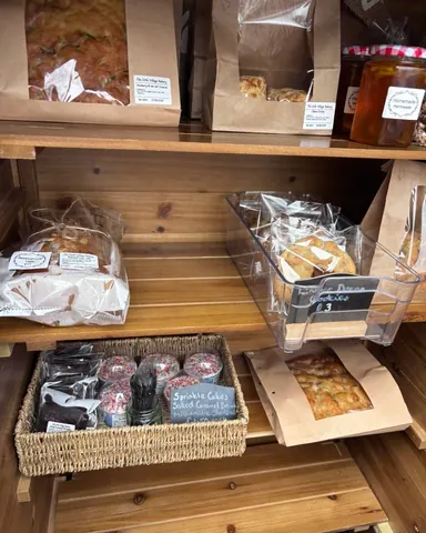 A wooden shelf with bags of food on it.