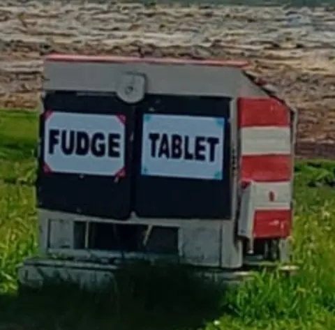 A red and white sign that says "Fudge Tablet" on it.