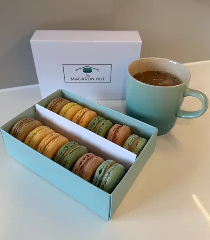 A box of macaron cookies and a cup of coffee.