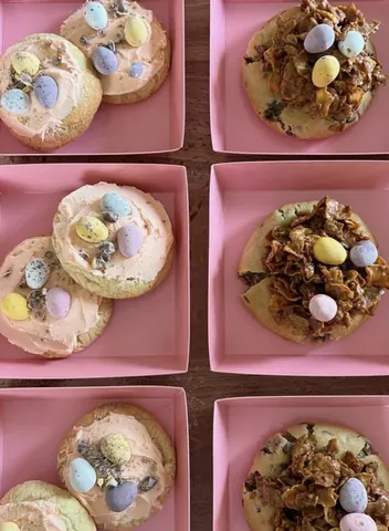 A pink tray with a cookie on it.