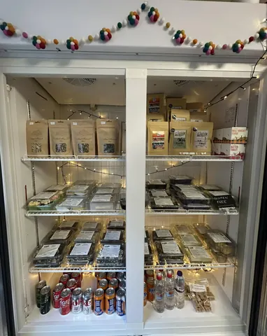 A refrigerator with a shelf full of food and drinks.