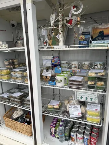 A refrigerator with a shelf full of food and drinks.