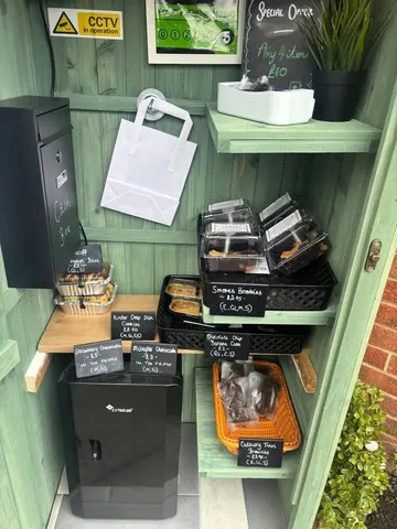 A small green shack with a black box and a white bag.