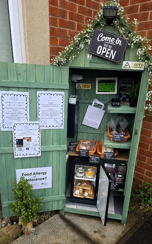 A small green building with a sign that says open.