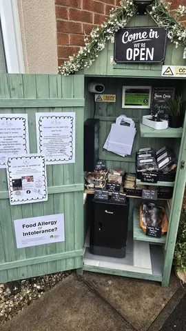 A small green building with a sign that says "Food Allergy Intolerance?"