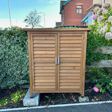 A wooden shed with a door and a window.