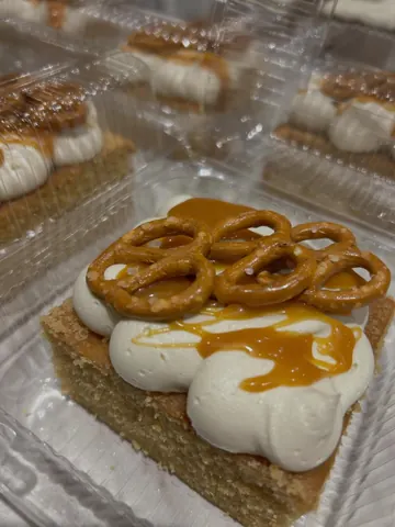 A dessert with a white frosting and a piece of cake.