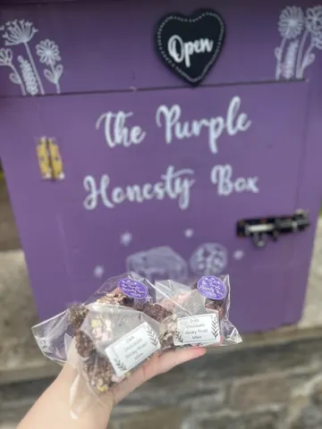 A person is holding a box of chocolates.