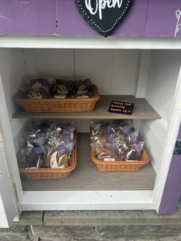 A white shelf with baskets of food on it.
