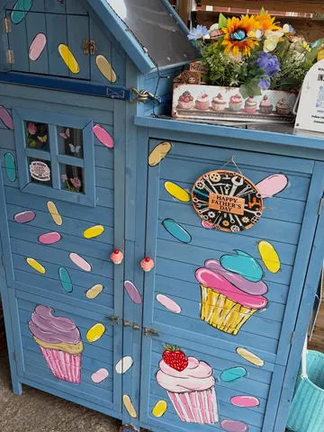 A blue cupcake cabinet with a strawberry on it.