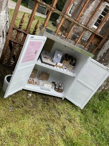 A white refrigerator with a pink sign on the door.