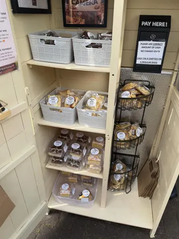 A display case with a sign that says "Please do not touch" and a variety of food items.