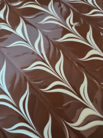 A chocolate cake with white frosting and swirls.