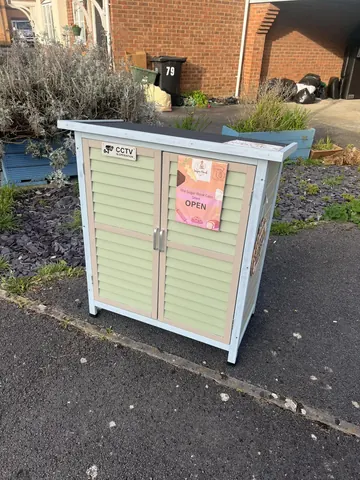 A blue and green box with a sign that says open.