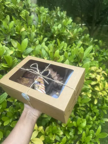 A person is holding a box with a picture of a cake in it.