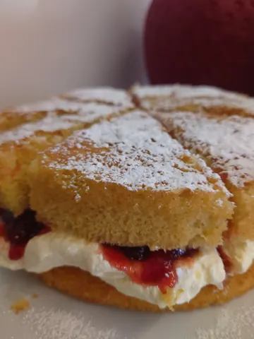 A pastry with white frosting and red jam.