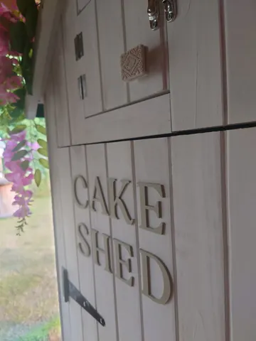 A white door with a cake shop sign on it.