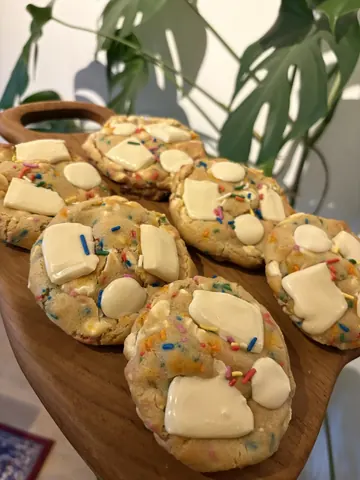 A wooden tray with a bunch of cookies on it.
