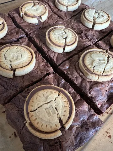 A chocolate cake with a cookie on top.