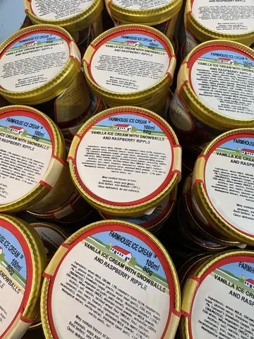 A stack of jars with a picture of a green field on the label.