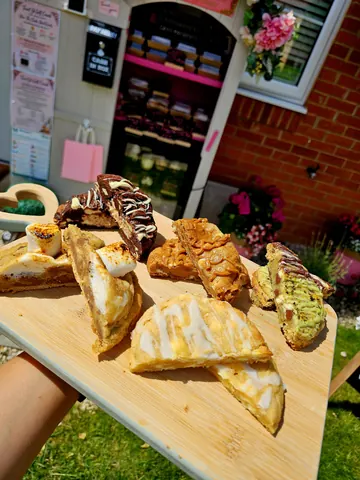 A wooden tray with a variety of desserts on it.