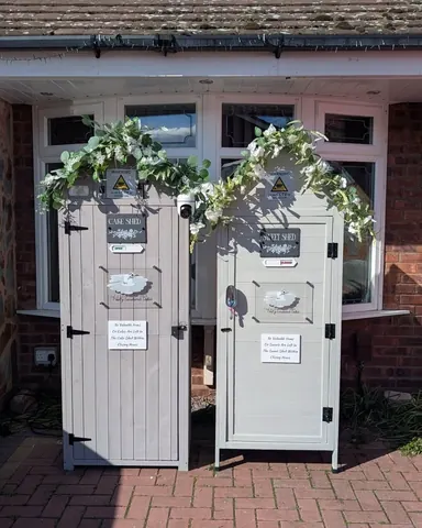 Two gray doors with white flowers on them.