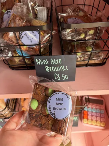A person is holding a bag of mint aero brownie.