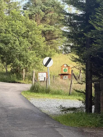 A sign on a pole with a green circle on it.