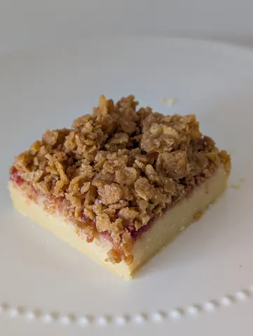 A square piece of cake with a crumbly topping.