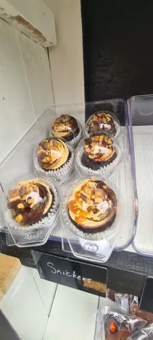 A box of chocolate cupcakes with caramel frosting.