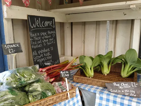 A sign welcoming visitors to a produce stand.
