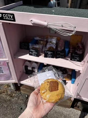 A person is holding a cookie in a wrapper.