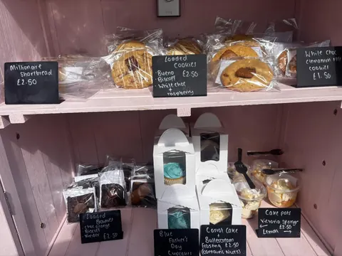 A pink shelf with a variety of food items on it.