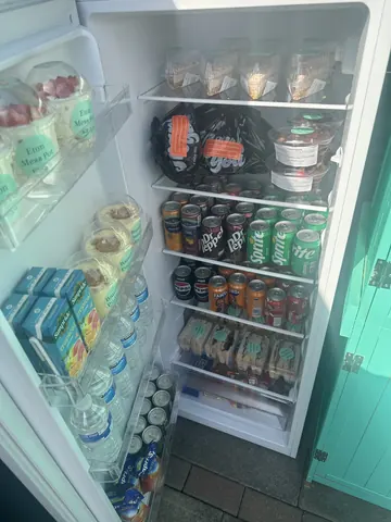 A refrigerator with a variety of food and drinks inside.