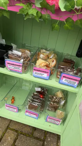 A display case with a variety of desserts in plastic containers.