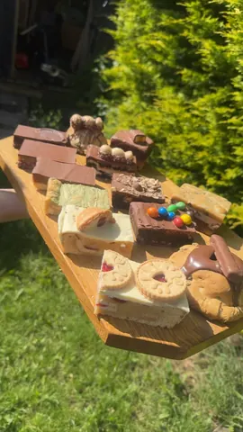 A wooden tray with a variety of desserts on it.