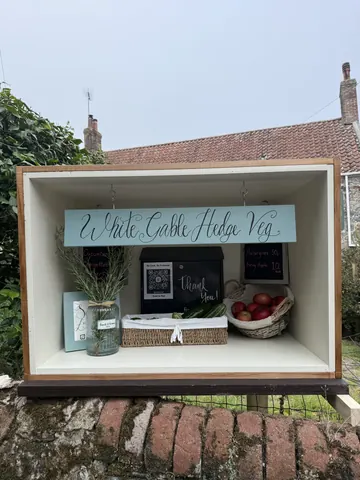 A wooden box with a sign that says "Little Castle Farm" on it.