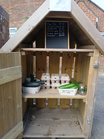 A wooden box with a chalkboard sign and a green plant in it.